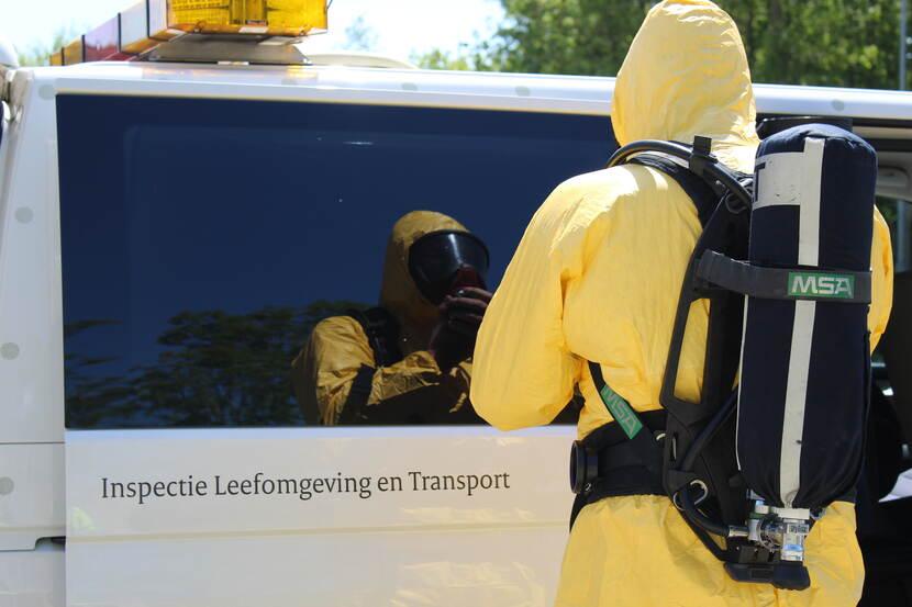 Man in een geel beschermpak achter een busje van ILT