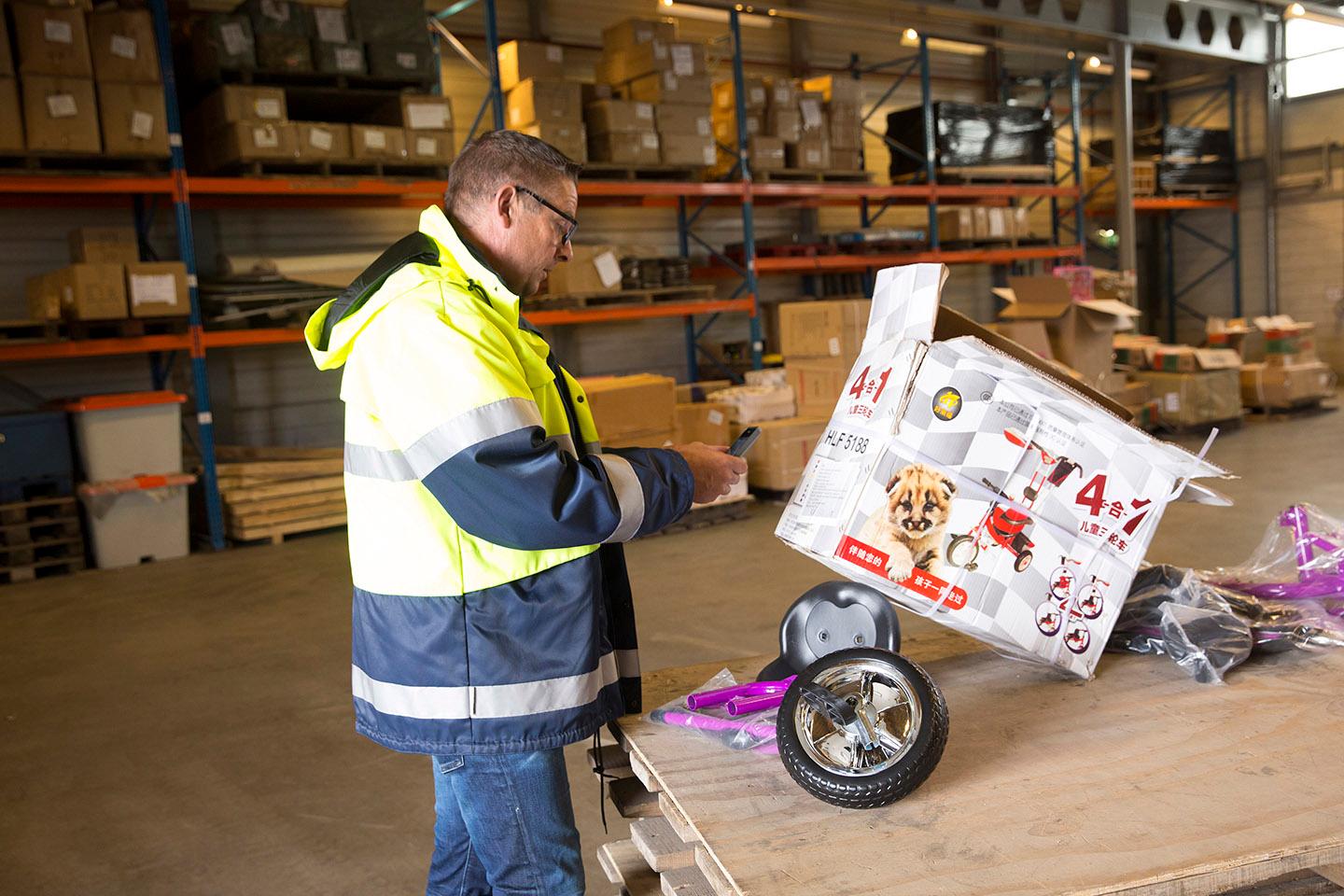 Man in werkkleding inspecteert een kinderfiets